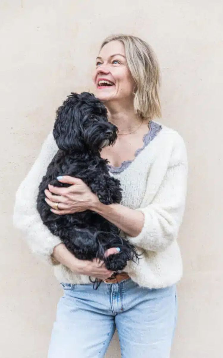 Luennoitsija Anna Stenberg pitää sylissään koiraa.